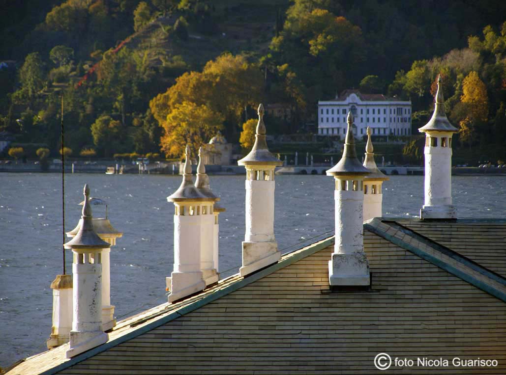 comignoli o camini sul tetto di villa melzi a bellagio sul lago di como con lo sfondo di villa carlotta