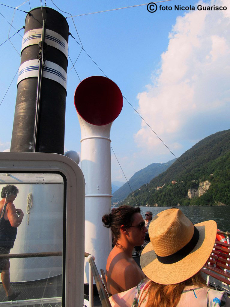 ciminiera o fumaiolo con la manica a vento ed un turista con cappello di paglia sul piroscafo concordia lago di como in navigazione, battello nave a vapore