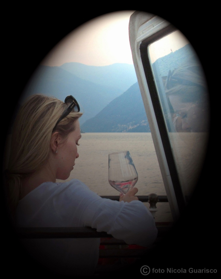 turista con drink o aperitivo a bordo del piroscafo concordia lago di como in navigazione, battello nave a vapore