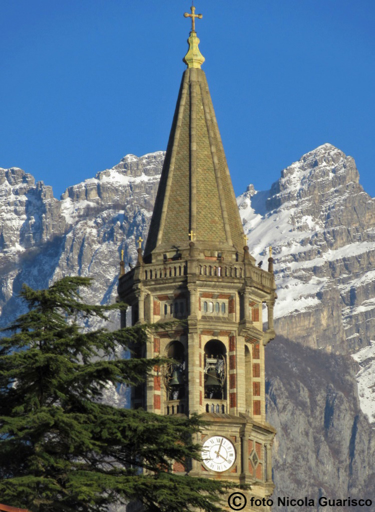 campanile di san nicolò nel centro storico di lecco sul lago di como con lo sfondo del monte resegone innevato in inverno