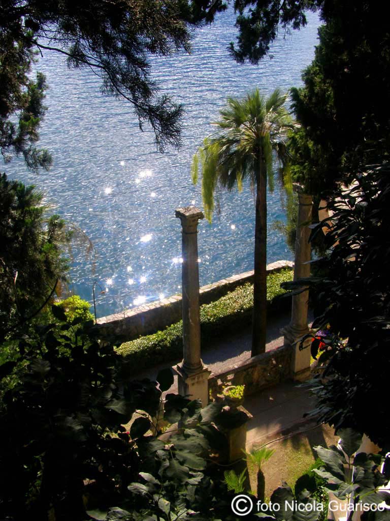 riflessi sull'acqua nel parco di villa monastero a varenna sul lago di como con palme e colonne